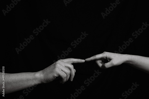 Photography Black and white image of two hands that are joined in the center by one finger