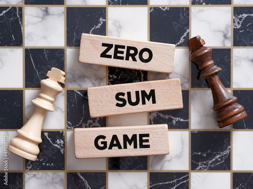 Foto Two chess piece kings lying on the chessboard with the word zero sum game on a wooden block