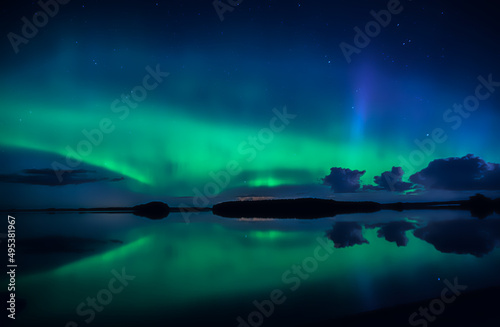 Northern lights dancing over calm lake in Farnebofjarden national park in north of sweden © Conny Sjostrom