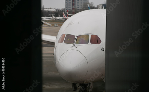 The front part of an airplane standing in parking mode and preparing the get the travellers on board.