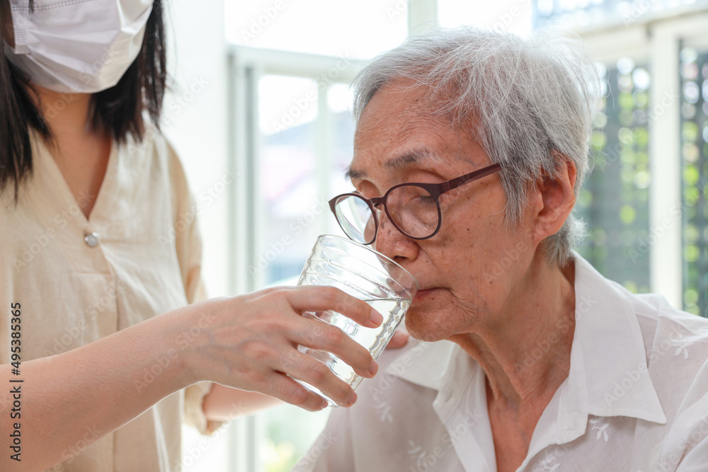 Nurse or caregiver gives water to senior woman,taking care,feeding water,thirsty asian old elderly drinking fresh water to quench their thirst in hot summer weather,preventing dehydration,health care Nurse or caregiver gives water to senior woman,taking care,feeding water,thirsty asian old elderly drinking fresh water to quench their thirst in hot summer weather,preventing dehydration,health care