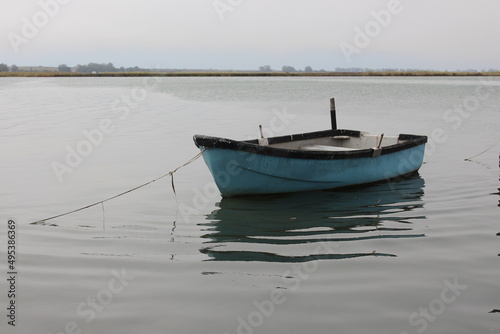 Old small blue fishing boat on water