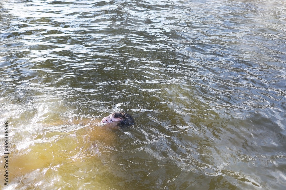 Obraz premium the boy swims or drowns in the water and there is no one around, you need to learn how to swim the child breathes