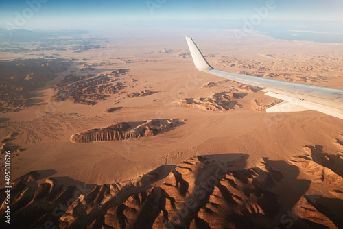 View from the plane on the wing and mountains in the desert of Africa photo