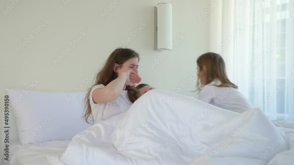 child wakes up parents in morning in bed. kid jumps with pillows in bedroom mom and dad. girl came to woman and man. Happy family hug plays and laughs together. Have fun and smile. Good mood of day. child wakes up parents in morning in bed. kid jumps with pillows in bedroom mom and dad. girl came to woman and man. Happy family hug plays and laughs together. Have fun and smile. Good mood of day.