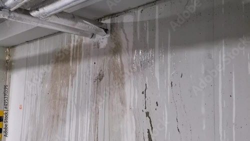 Water stains on a concrete wall of an underground garage, pipe malfunction