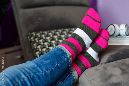 Close-up of woman wearing Magenta socks while resting for workout on a sofa at home. 