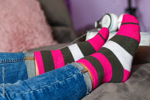Close-up of woman wearing Magenta socks while resting for workout on a sofa at home. 