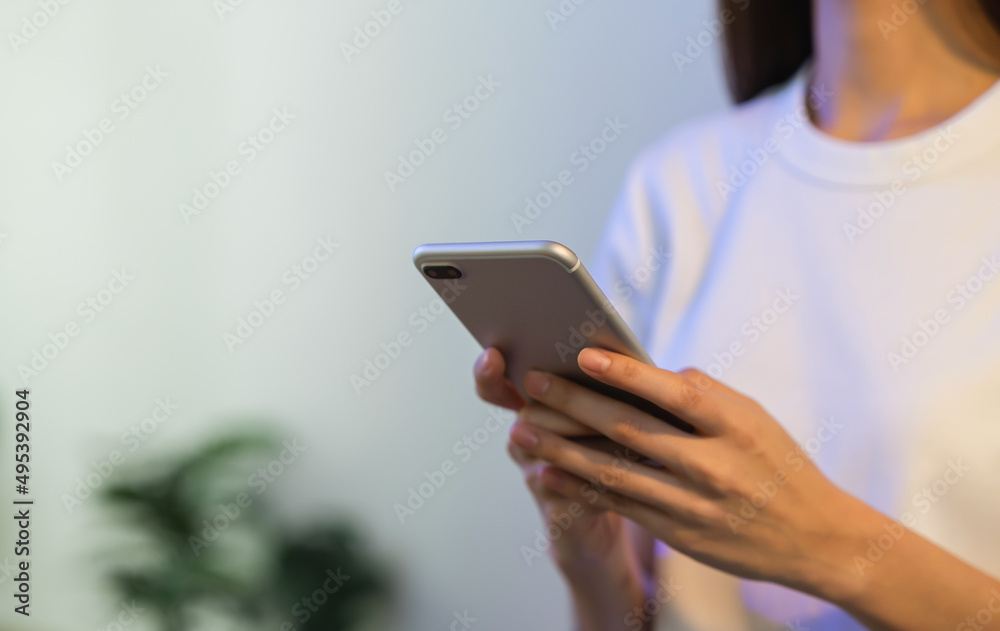 Hand holding smartphone and chatting with friends at social network on the table.