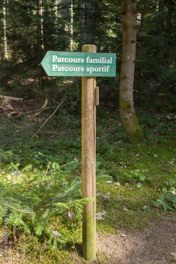 Panneau de signalisation en bois indiquant la direction d'un parcours familial et d'un parcours sportif