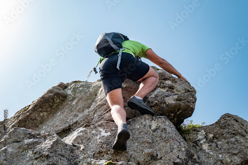 Jovem turista a escalar um monte rochoso photo