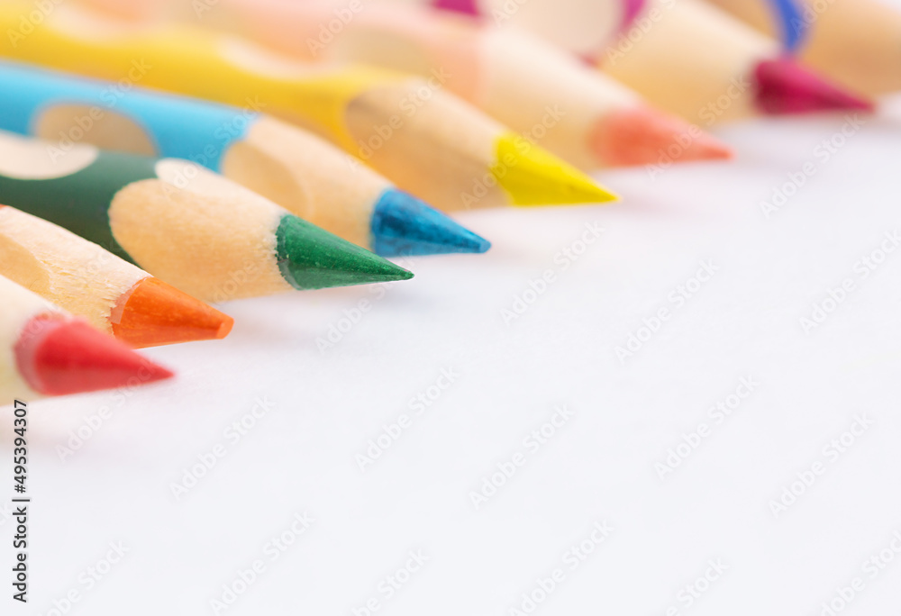 Color pencils on a white background with copy space. Ergonomic triangular colored pencil with non-slip grip moulds. Learning the correct writing. Selected focus Color pencils on a white background with copy space. Ergonomic triangular colored pencil with non-slip grip moulds. Learning the correct writing. Selected focus