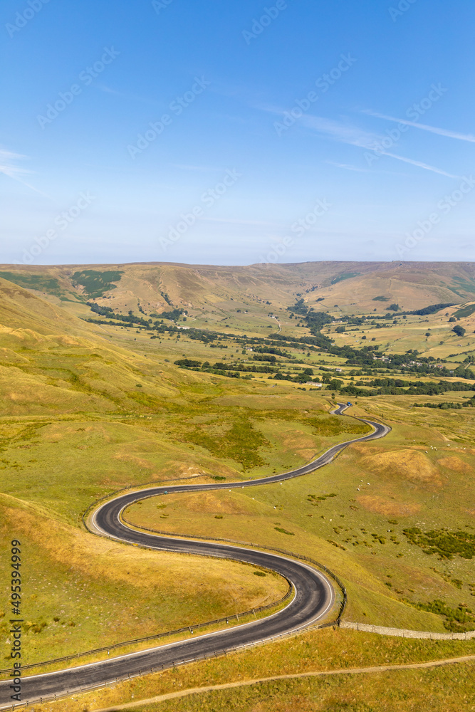 Beautiful winding road and hills in the Peak District on a sunny day