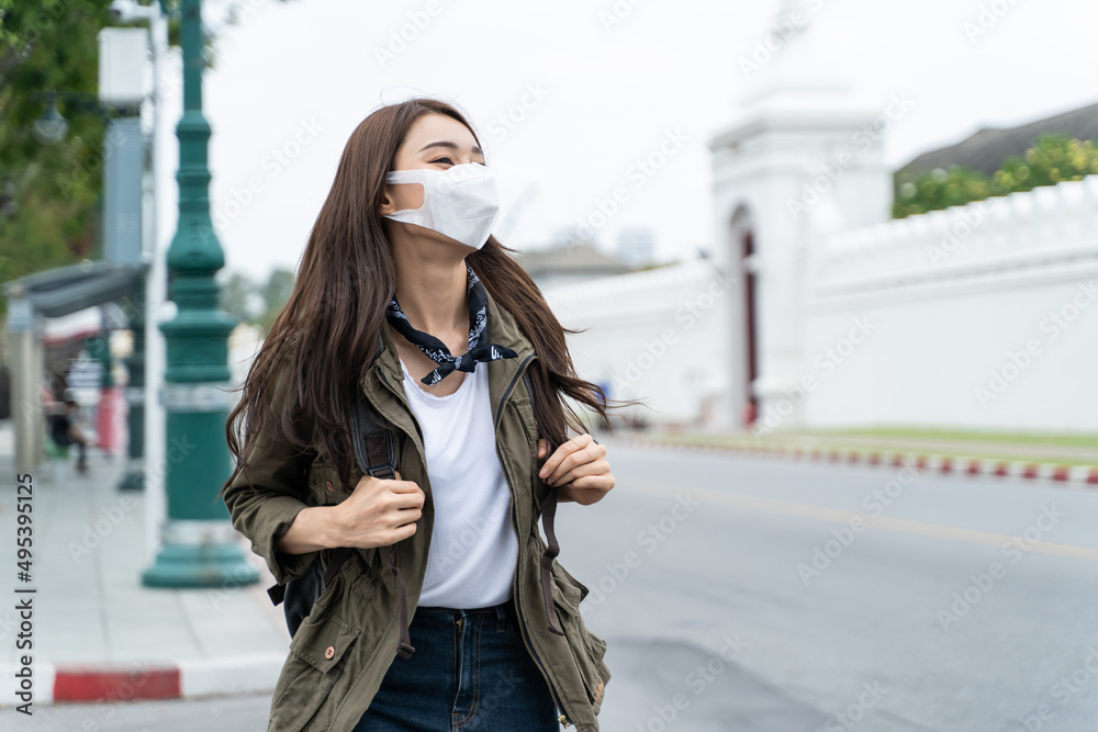 Asian attractive woman backpacker wear protective mask, walk in city. 