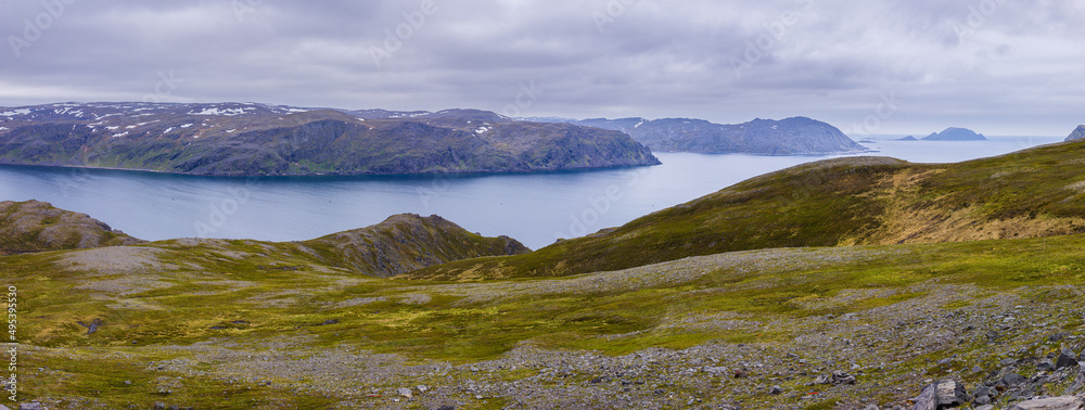 Fototapeta premium panorama image of a landscape with fjord and mountains on the isle of Mageroya in northern Norway