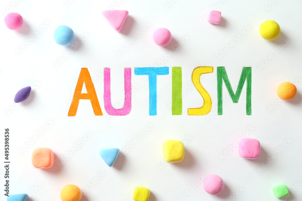 Word Autism and colorful plasticine figures on white background, flat lay