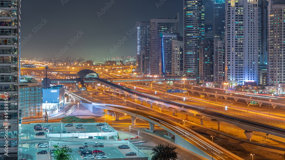 Fototapeta premium Dubai Marina skyscrapers and Sheikh Zayed road with metro railway aerial night timelapse, United Arab Emirates