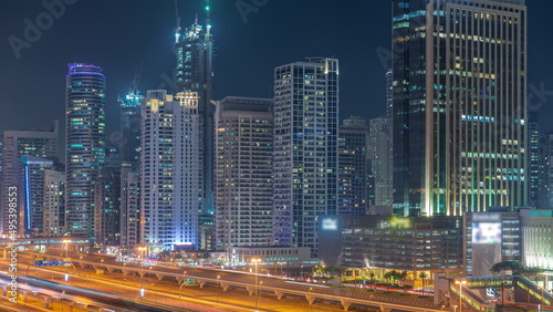 Dubai Marina skyscrapers and Sheikh Zayed road with metro railway aerial night timelapse, United Arab Emirates