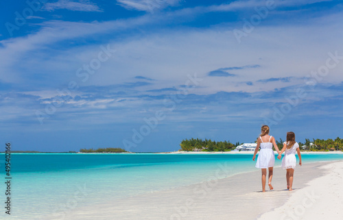 Healthy young Caucasian siblings walking along Caribbean beach