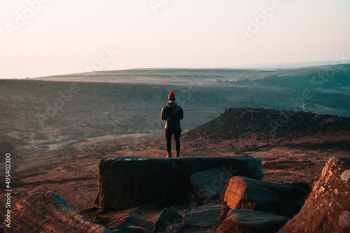 Person watching the mountain on Higger Tor in Peak District National Park , England, UK