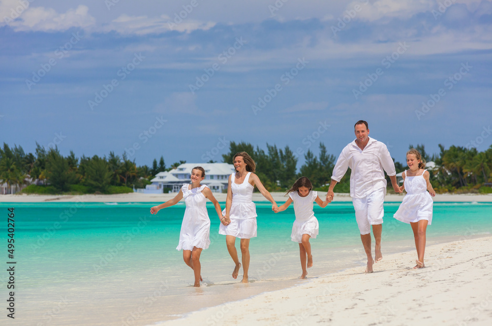 Happy Caucasian family having fun by tropical ocean