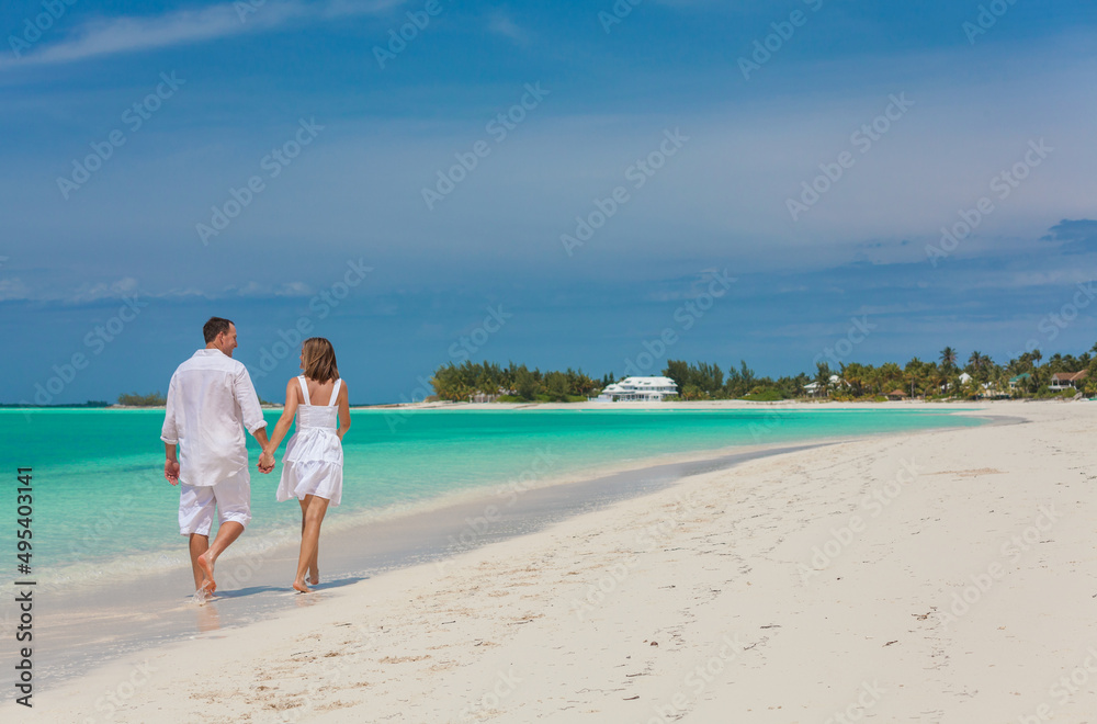 Romantic Caucasian couple walking on a beach together Romantic Caucasian couple walking on a beach together