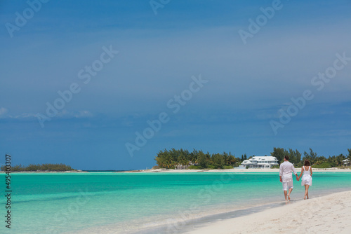 Romantic Caucasian couple walking on beach for relaxation