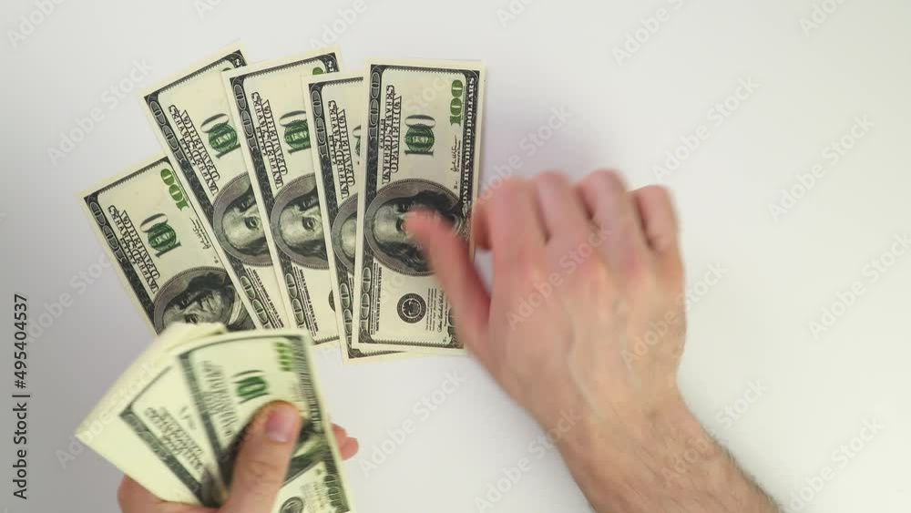 Dollars on a white background. Count money top view. Caucasian male hands shift banknotes. Wealth concept. Get paid in cash and pay taxes. Count one dollar.