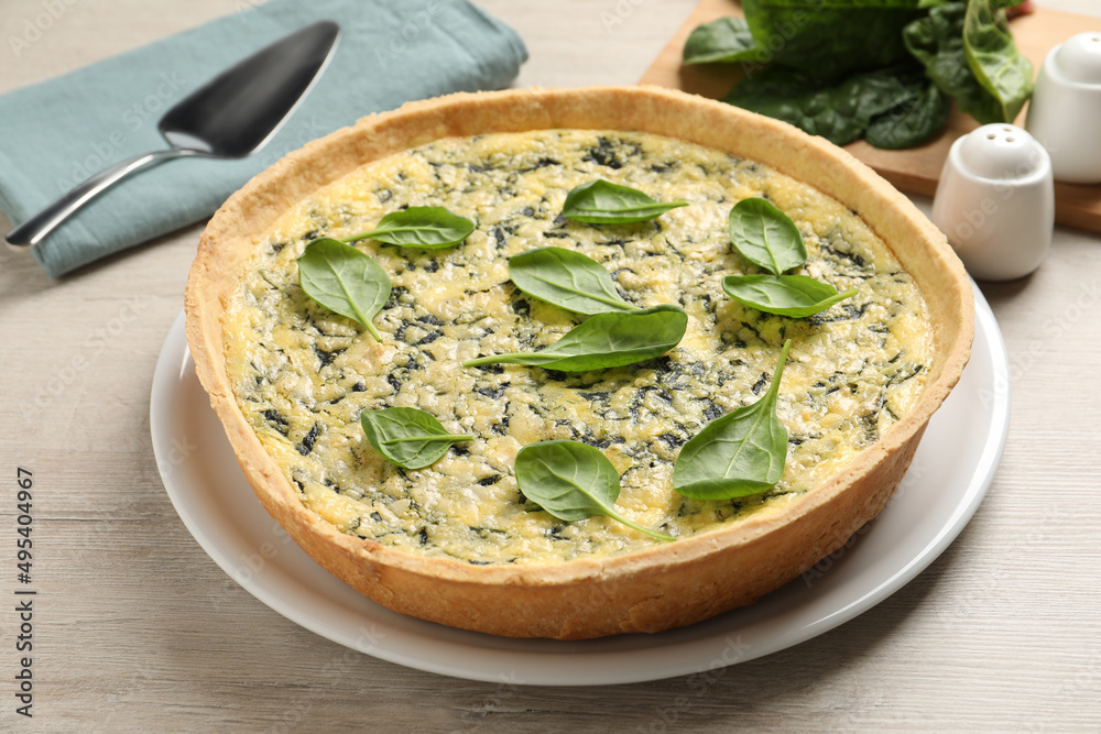 Delicious homemade spinach pie on white wooden table