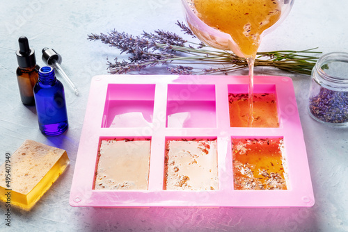 Soap making at home. Liquid glycerin with the additives of peels and flower buds poured into a mould, with essential oils