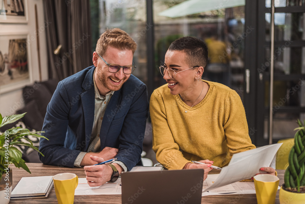 Smiling short haired woman, showing a file to her male business partner. Smiling short haired woman, showing a file to her male business partner.