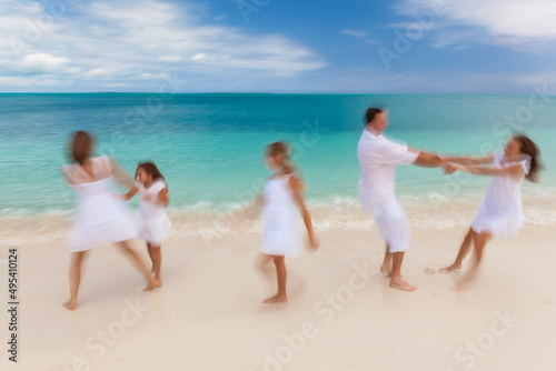 Caucasian parents and daughters playing on island beach