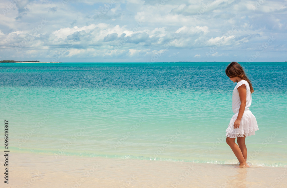 Healthy young Caucasian girl walking along Caribbean beach