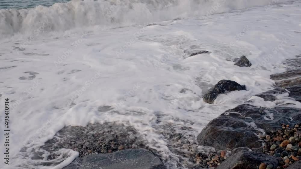 Sea coast with pebble beach in windy weather with waves, splashes and foam. Beautiful landscape in the sunlight. Black Sea. High quality 4k footage Sea coast with pebble beach in windy weather with waves, splashes and foam. Beautiful landscape in the sunlight. Black Sea. High quality 4k footage
