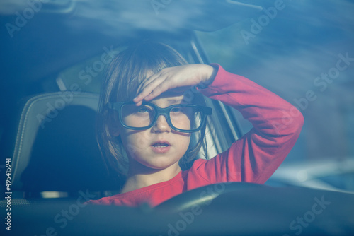 Dangers and risks of underage driving. Portrait of young girl drives a car.