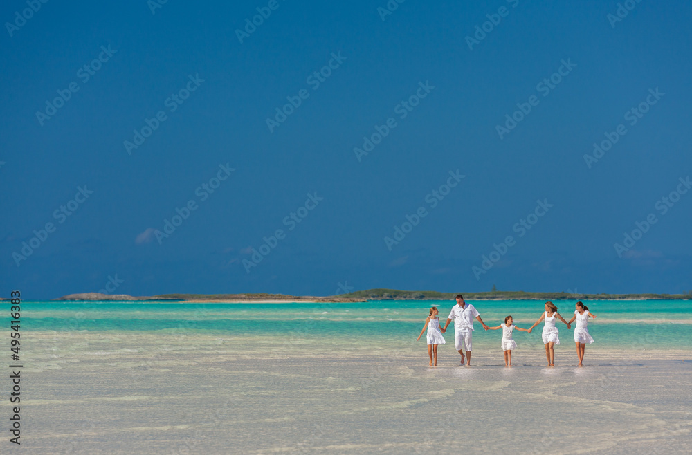 Barefoot Caucasian parents and daughters on beach Caribbean