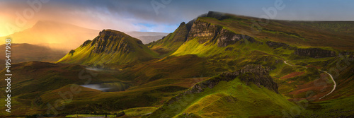 Epic panoramic view of Hebrides mountains on The Trotternish Ridge with incoming rain shower and beautiful golden light. Quiraing, Isle of Skye, Scotland, UK. photo