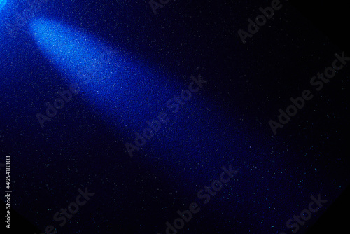 On a dark blue gradient background, a blue diagonal beam of light