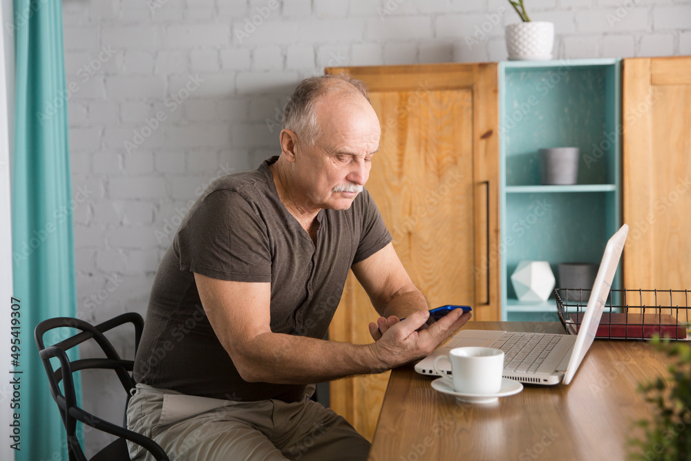 elderly man connecting to the Internet from home. healthy seniors lifestyle. work from home. Senior man using a laptop, in a stylish living room, elderly man connecting to the Internet from home. healthy seniors lifestyle. work from home. Senior man using a laptop, in a stylish living room,