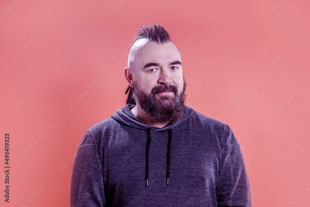 Portrait of an adult man with a mohawk and dreadlocks. A middle-aged man with a beard and an unusual hairstyle Portrait of an adult man with a mohawk and dreadlocks. A middle-aged man with a beard and an unusual hairstyle