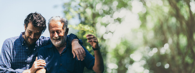 senior father with adult son in family concept banner background with copy space, elderly old man person are happy and enjoy with hipster son together by walking outdoor in nature