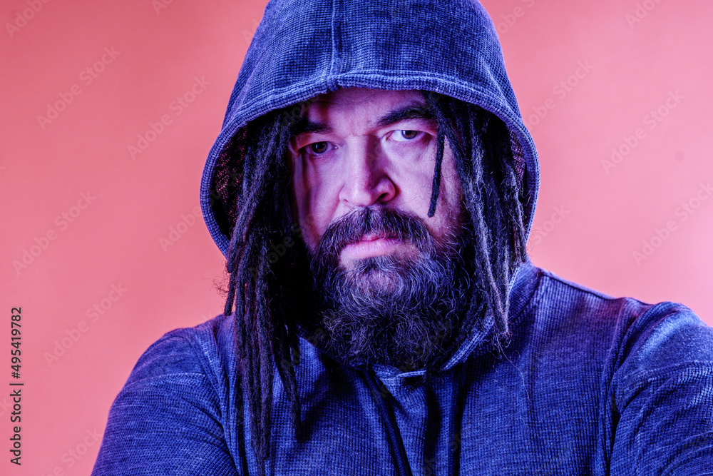 A dangerous man with a mohawk and dreadlocks covered with a hood. A middle-aged man with a beard and an unusual hairstyle. Menacing appearance A dangerous man with a mohawk and dreadlocks covered with a hood. A middle-aged man with a beard and an unusual hairstyle. Menacing appearance