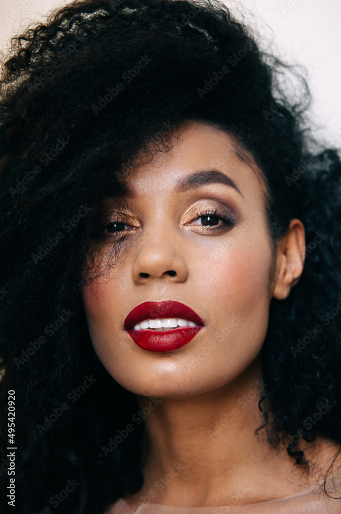 Clear, even skin. Photo session outdoors with natural light. Portrait of a smiling woman model. Black healthy curly hair. Clear, even skin. Photo session outdoors with natural light. Portrait of a smiling woman model. Black healthy curly hair.
