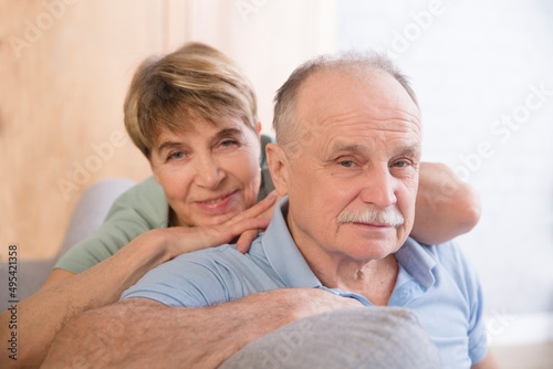 healthy seniors lifestyle. relaxing at home. portrait smiling a loving elderly couple hugs and looking at camera at home