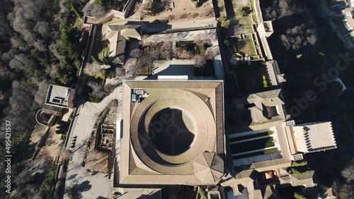 Drone flying over Charles V Palace inside Alhambra citadel with cityscape in background, Granada in Spain. Aerial forward tilt up reveal