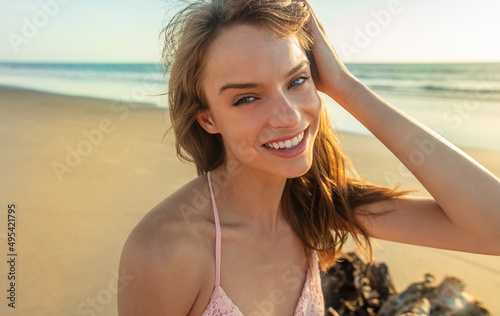 Smiling young American girl on beach at sunrise