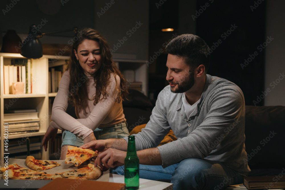 couple spending time together eating pizza at home couple spending time together eating pizza at home