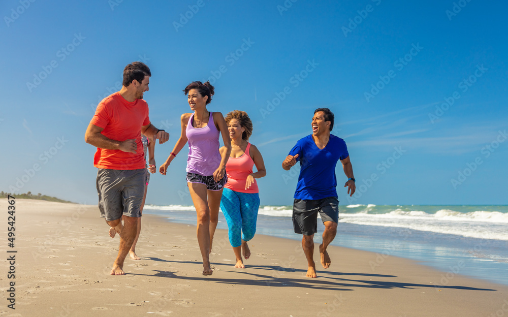 Fitness loving friends in sportswear running on beach