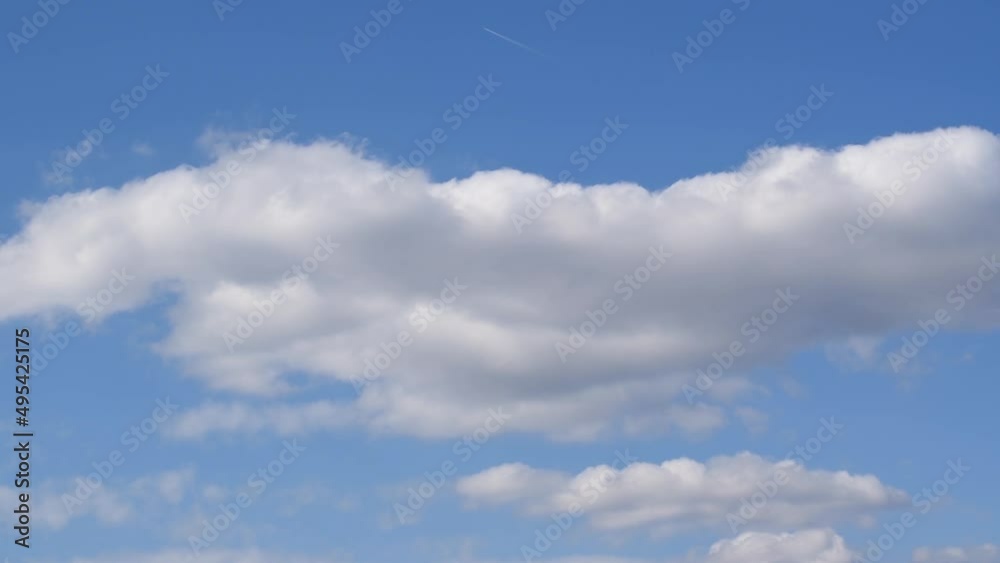 Soft fluffy cumulus clouds passing by against blue sky time lapse, bright cloud changing and moving over sky Soft fluffy cumulus clouds passing by against blue sky time lapse, bright cloud changing and moving over sky
