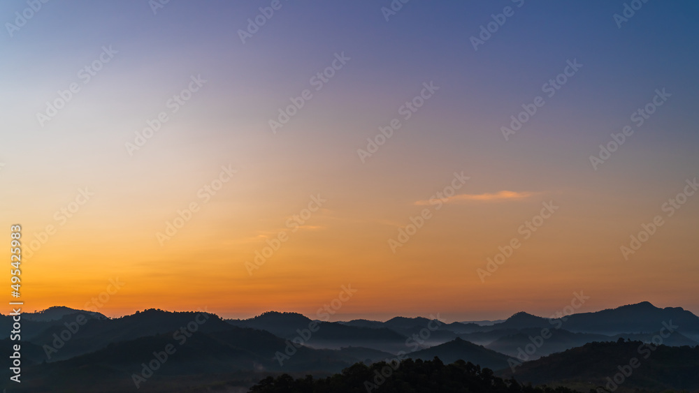 sunset over the mountains in the morning with colorful orange sunrise